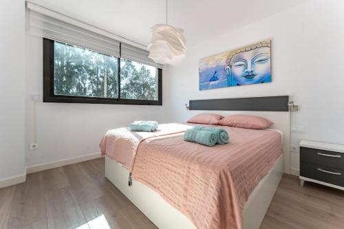 a bedroom with a bed with pink and blue pillows at 206 Navigolf 3 in La Cala de Mijas