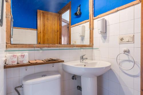 a bathroom with a sink and a toilet and a mirror at Apartamento El Tinao in La Zubia