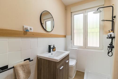 a bathroom with a sink and a mirror and a toilet at Susurros de río in Ocejo