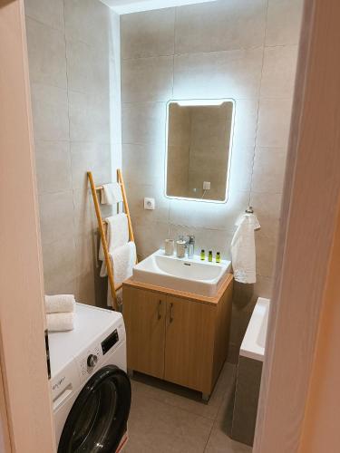 a bathroom with a sink and a mirror at Bloom Olive Apartment in Trenčín