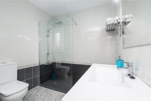 a bathroom with a toilet and a glass shower at Can Navarro in Llucmajor