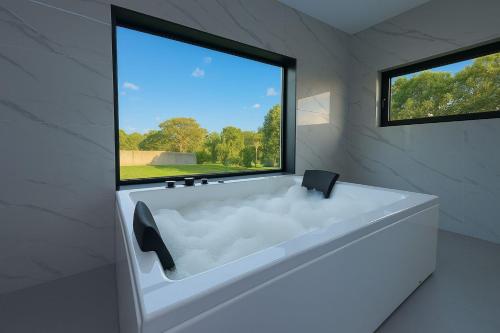 a white bath tub in a room with a window at Bella Casa Total House in São Francisco