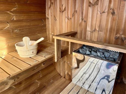 an inside view of a wooden sauna with a bucket at Chalet Delphine Luxe, Ski aux pieds in Les Bruyères
