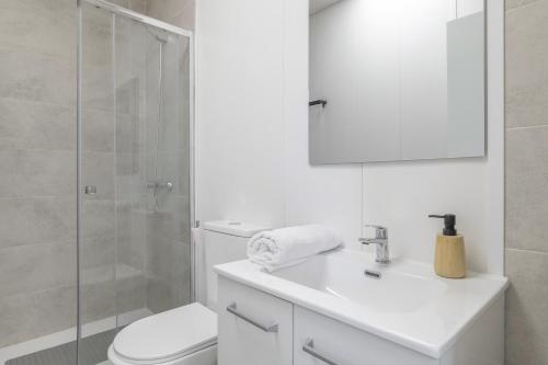 a white bathroom with a toilet and a shower at Apartamento Ajm in Barbate