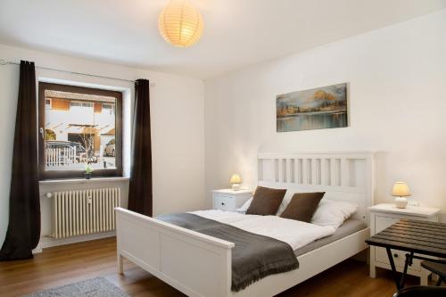 a bedroom with a white bed and a window at Weinberg in Zeilarn