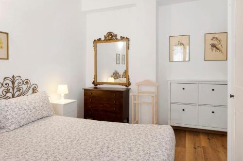 a bedroom with a bed and a mirror and a dresser at Super Mini Appartamento Lanzada in Lanzada