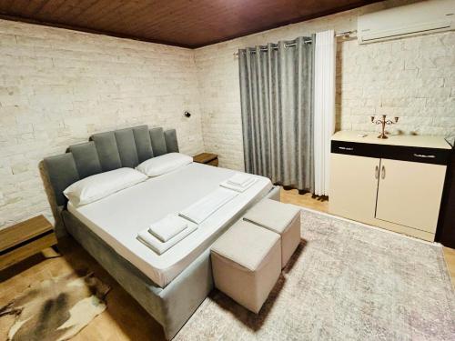 a bedroom with a large white bed and a sink at Siera Home in Berat