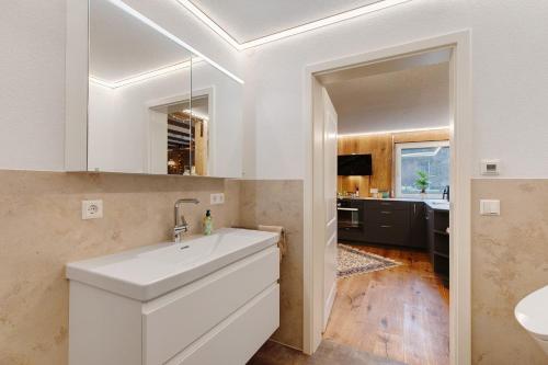 a white bathroom with a sink and a mirror at Ferienwohnung an der Lauter in Indelhausen