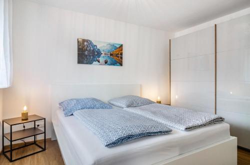 a white bedroom with a bed and a table at Apartment Jegle in Salem