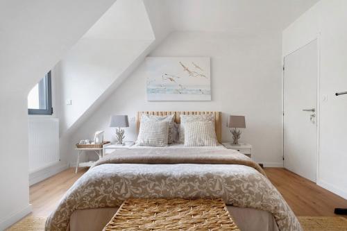 a white bedroom with a large bed and a staircase at Chambres D'hôtes Les Goélands in Saint-Cast-le-Guildo
