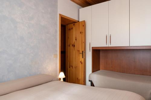 a bedroom with two beds and a door and cabinets at Simona in Fetovaia