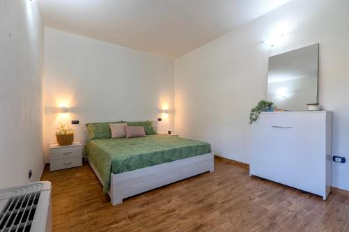 a small bedroom with a bed and a refrigerator at Casa Rinascita con Piscina Privata in Nulvi