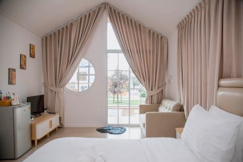 a bedroom with a bed and a large window at Terra Sky Home in Pak Chong