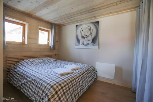 a bedroom with a bed and a picture of a horse at Gite Cairn, Rez De Chalet in Faverges