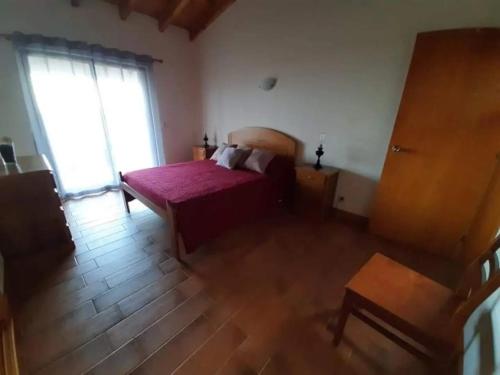 a bedroom with a bed and a large window at Ocean Melody in Canto da Areia