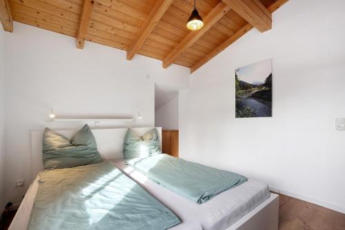 a bedroom with a bed in a room with wooden ceilings at Schnitzer Ferienwohnung in Görisried