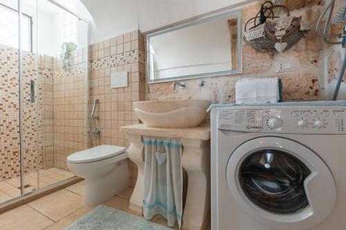 a bathroom with a washing machine and a sink at Trullo Milù in San Michele Salentino