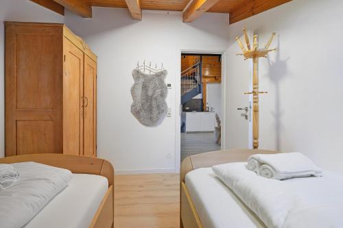 a bedroom with two beds and a cross on the wall at Goodlife B10 in Saalbach-Hinterglemm