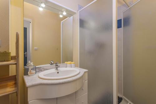 a bathroom with a sink and a shower at Maison Goéland in Le Barcarès