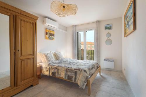 a bedroom with a bed and a window at Maison Goéland in Le Barcarès
