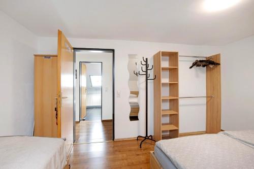 a bedroom with two beds and a closet with shelves at Ferienwohnung Dani in Koetz 