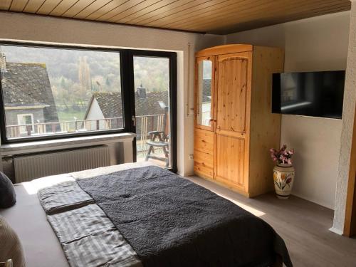 a bedroom with a bed and a large window at Haus Milaneva in Klotten