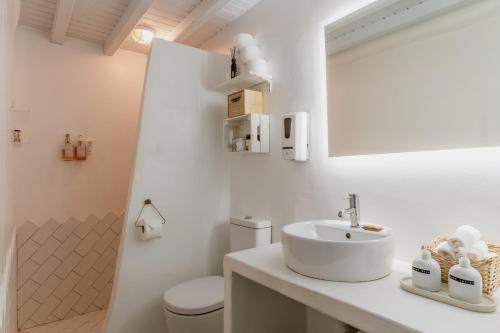 a white bathroom with a sink and a toilet at 5-Bed Stylish Maisonette in Mikonos