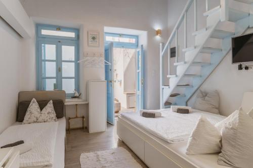 a white room with a bed and a staircase at 5-Bed Stylish Maisonette in Mikonos