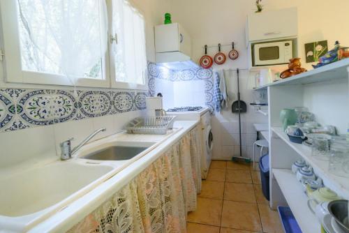 a kitchen with a sink and a microwave at Chambres D'hôtes in Saint-Cyprien