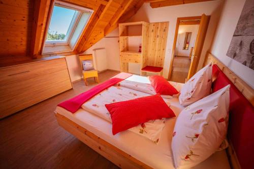 a bedroom with a large bed with red pillows at Ferienhaus Bührer in Freiamt