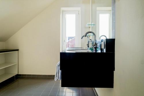 a kitchen with a sink and two windows at Ferienhaus Jümmers - Sönke in Horumersiel