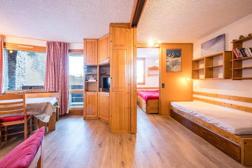 a small room with two beds and a table and a table at Appartement 46 - Les Coches in La Plagne Tarentaise
