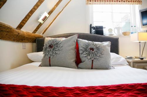a bedroom with a bed with two pillows on it at The Miller of Mansfield in Goring
