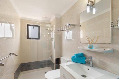 a bathroom with a sink and a toilet and a mirror at Lirio Blanco de las Dunas Canarias in Playa del Ingles