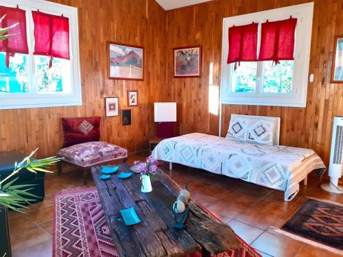 a bedroom with a bed and a table and windows at Chambre D'hôtes Agapanthe in Feytiat