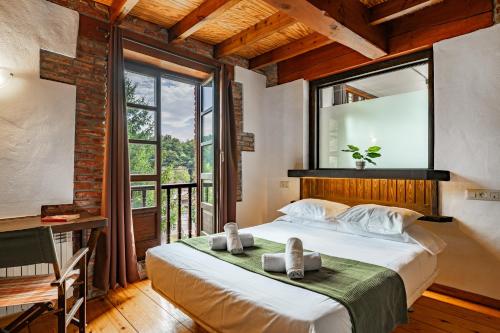 a bedroom with a bed and a desk and a window at Casa Florenta G3 in Cangas de Onís