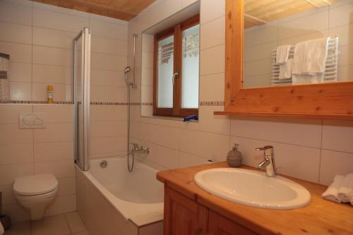 a bathroom with a sink and a tub and a toilet at Mayen de l'Art d Vivre in Crans-Montana