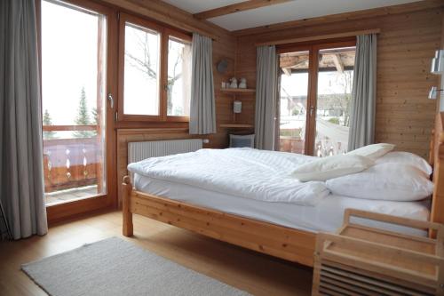 a bedroom with a bed with white sheets and pillows at Mayen de l'Art d Vivre in Crans-Montana