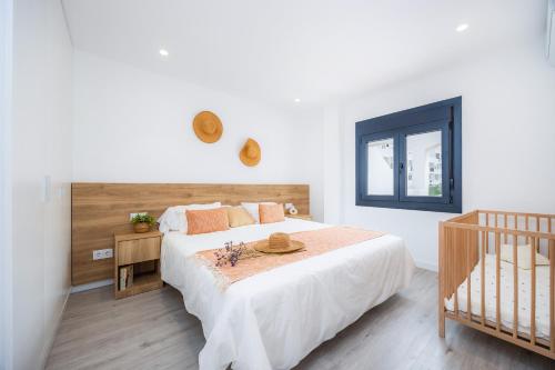 a bedroom with a bed and a crib at White suites 2 in Cala d´Or