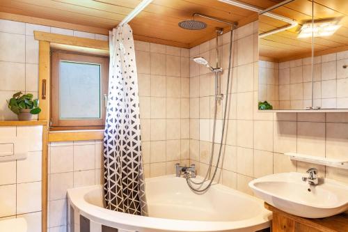 a bathroom with a tub and a sink and a shower at The Farm in Westendorf