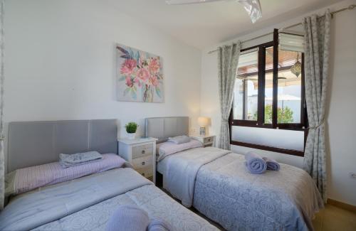 a bedroom with two beds and a window at Villa Petruca in Playa Blanca