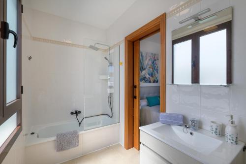 a bathroom with a tub and a sink and a shower at Villa Petruca in Playa Blanca