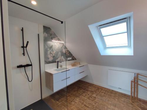 a bathroom with a sink and a window at Villa Cotton-vue mer et jacuzzi-6ch in Plobannalec-Lesconil
