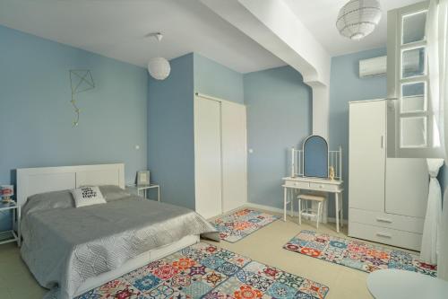 a bedroom with blue walls and a bed and a mirror at Palati in Kefallonia