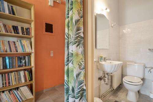 a bathroom with a toilet and a book shelf with books at Palati in Kefallonia