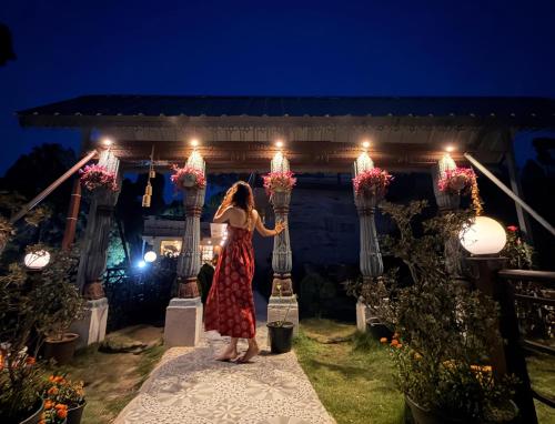 a woman in a red dress is holding up lights at ilika Resort - A Boutique Stay 30 km from Devprayag in Pauri