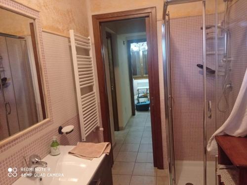a bathroom with a shower and a sink and a mirror at Villa Fiorita in Budoni