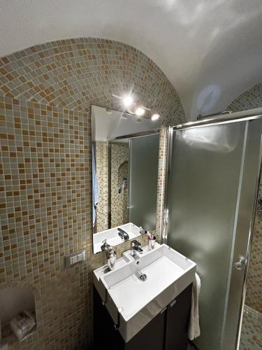 a bathroom with a sink and a shower and a mirror at Dammuso Cristoforo Colombo in Pantelleria