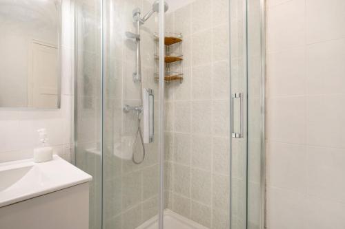 a shower with a glass door next to a sink at Prealsa Benalmádena in Benalmádena