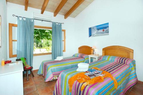 a bedroom with two beds and a window at Villa Burgues in Alcudia